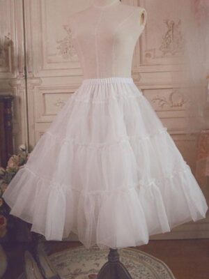 White lolita petticoat underskirt with layered ruffled tulle displayed on dress form in vintage European interior setting front oblique view showing fluffy bell silhouette