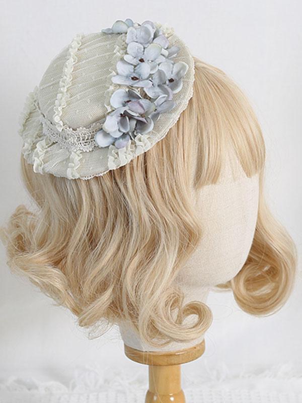 Side view of beige mesh Rococo Lolita mini hat with light blue hydrangea flowers and ruffled lace trim displayed on mannequin head with wig stand