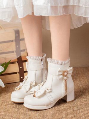 White sweet lolita ankle boots with ruffled collar and tassel bow, front overhead view with model wearing white ruffled lolita dress and block heel