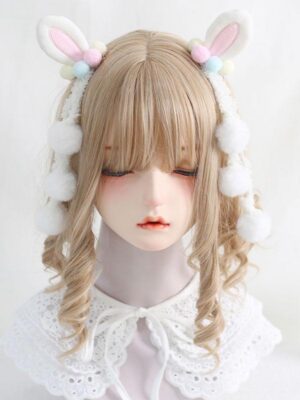 Pastel white bunny ear lolita headdress with pink inner lining worn on mannequin featuring light brown curly wig and lace collar, front eye-level view showing fluffy pom-pom tassels and rococo sweet lolita aesthetic