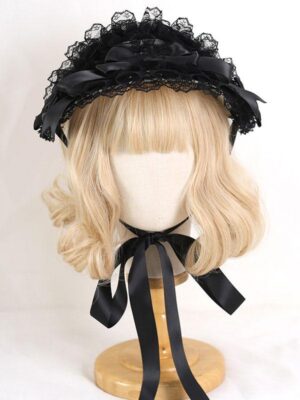 Black lace Lolita headdress with satin bow and ruffled trim on mannequin with blonde curly wig front view rococo style lolita accessory