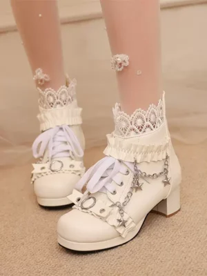 White Rococo Lolita ankle boots with layered lace ruffles and star chain charms, front close-up view on model wearing heart-patterned sheer socks, block heel design