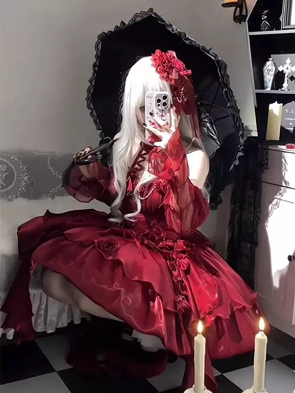 Gothic Lolita burgundy dress low-angle front view with sheer long ruffled sleeves, 3D rose skirt decorations, model holding gothic umbrella, detailed floral embellishments