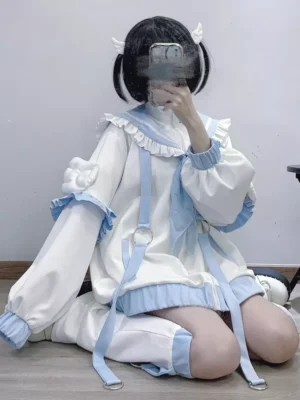 Sailor collar Lolita zip-up parka front seated view featuring white and baby blue color scheme with ruffled trims and lantern sleeves worn with twin bun hairstyle and wing hair clips