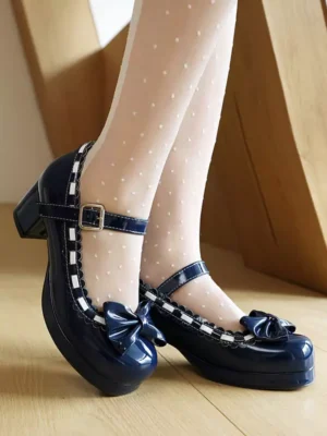 Navy blue patent leather Mary Jane Lolita shoes with front bow and ankle strap, styled with polka-dot sheer socks on wooden floor showing side profile and glossy finish
