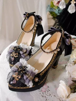 Gothic Lolita platform pumps with deep blue fabric bows and golden embroidered trim displayed on ornate lace table with decorative flowers and jeweled accents