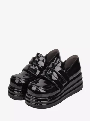 Black patent leather Gothic Lolita platform shoes with double velcro straps front oblique view displaying round toe and thick layered sole