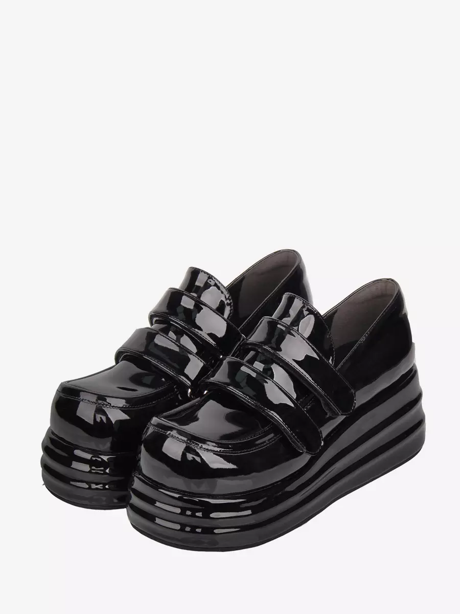 Black patent leather Gothic Lolita platform shoes with double velcro straps front oblique view displaying round toe and thick layered sole
