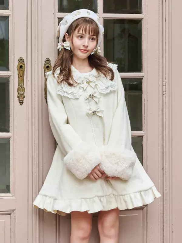 White sweet lolita winter coat with sailor collar and faux fur cuffs worn by model with matching beret in front of retro French door interior