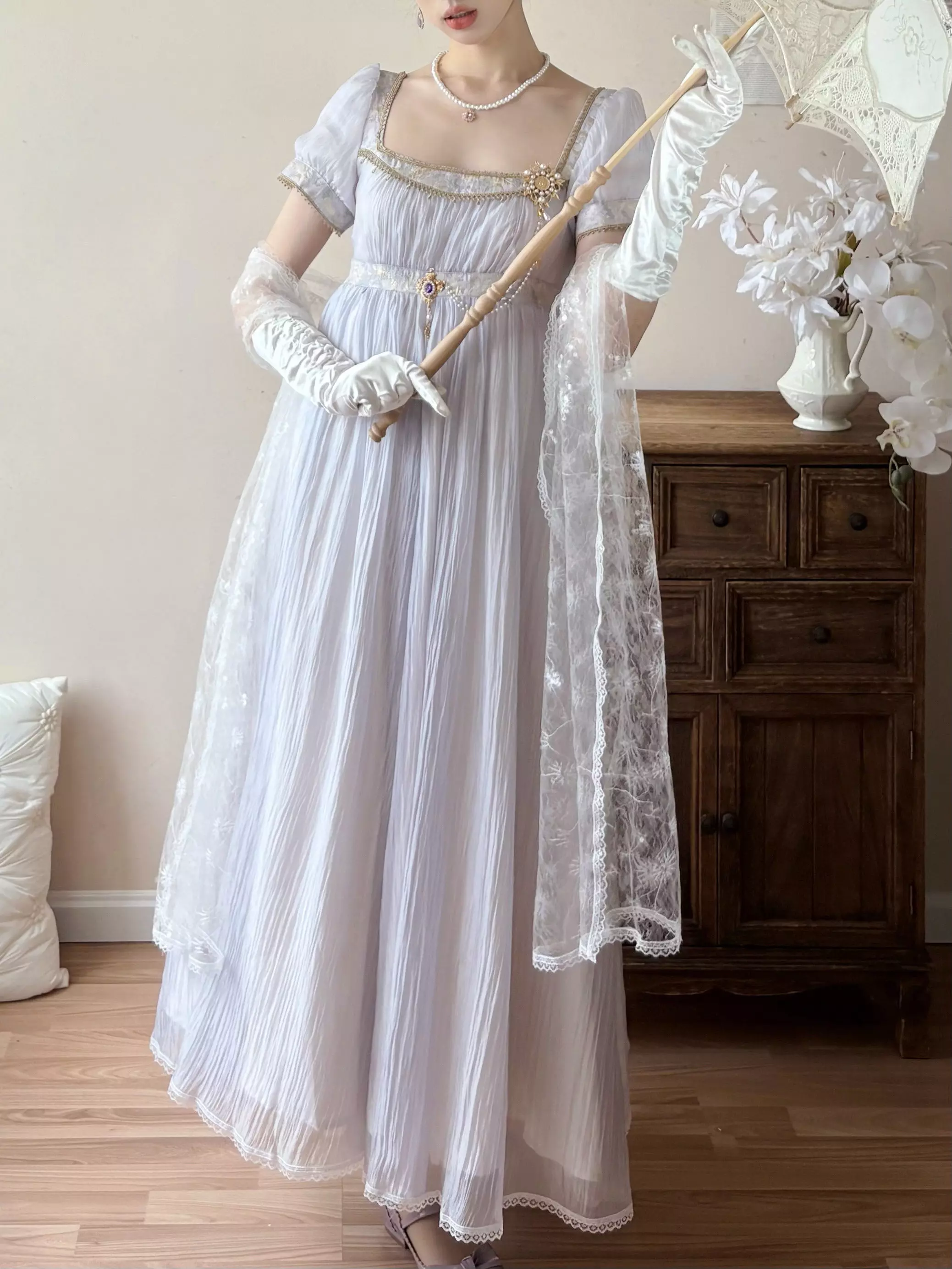 Side profile of purple Regency Lolita gown with square puff sleeves, empire waist, styled with white lace shawl, white gloves, and vintage parasol accessory