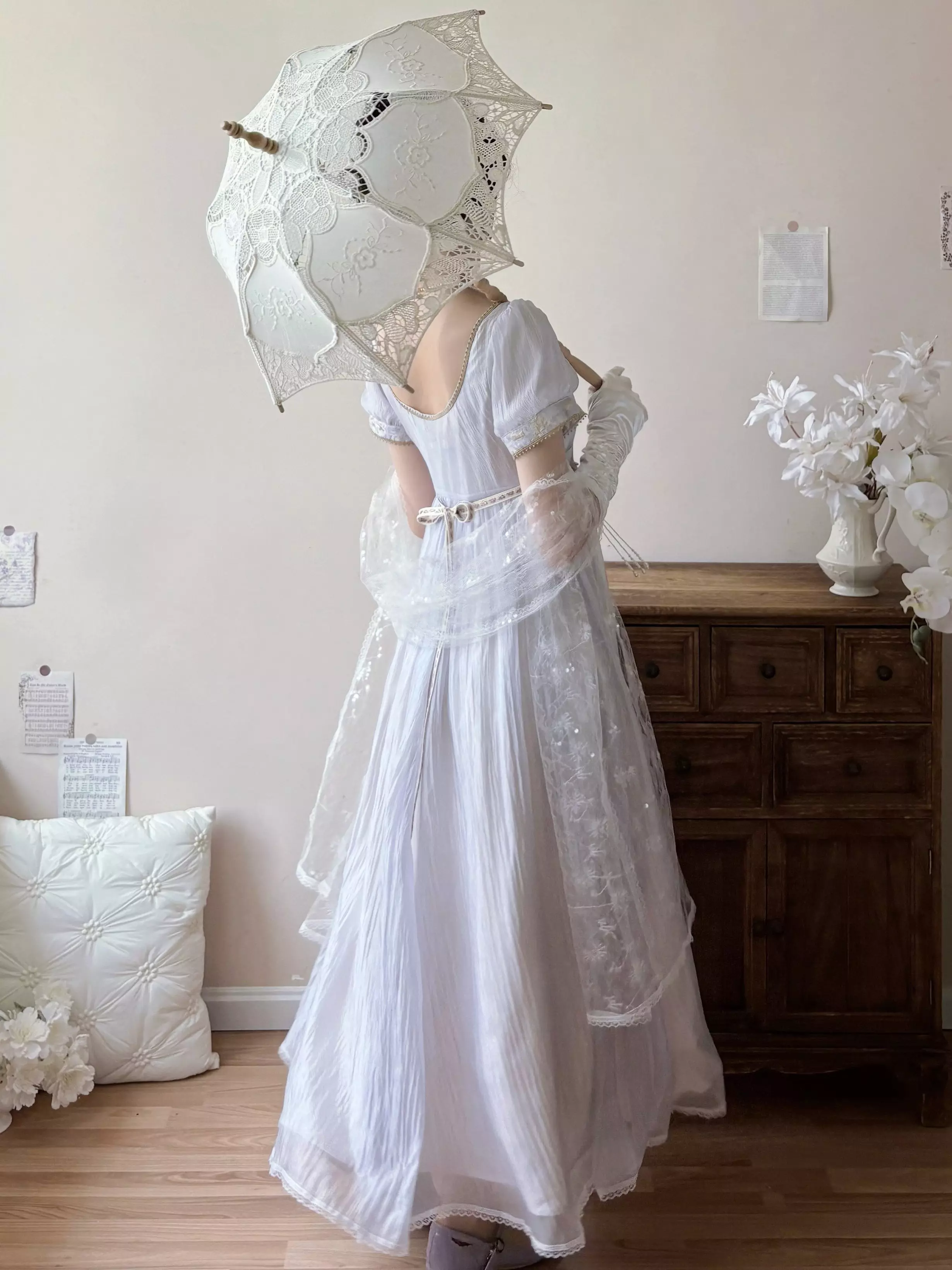 Back view of lavender Lolita Regency evening gown showing square back neckline, puff sleeves, empire waist construction, with attached lace shawl and parasol