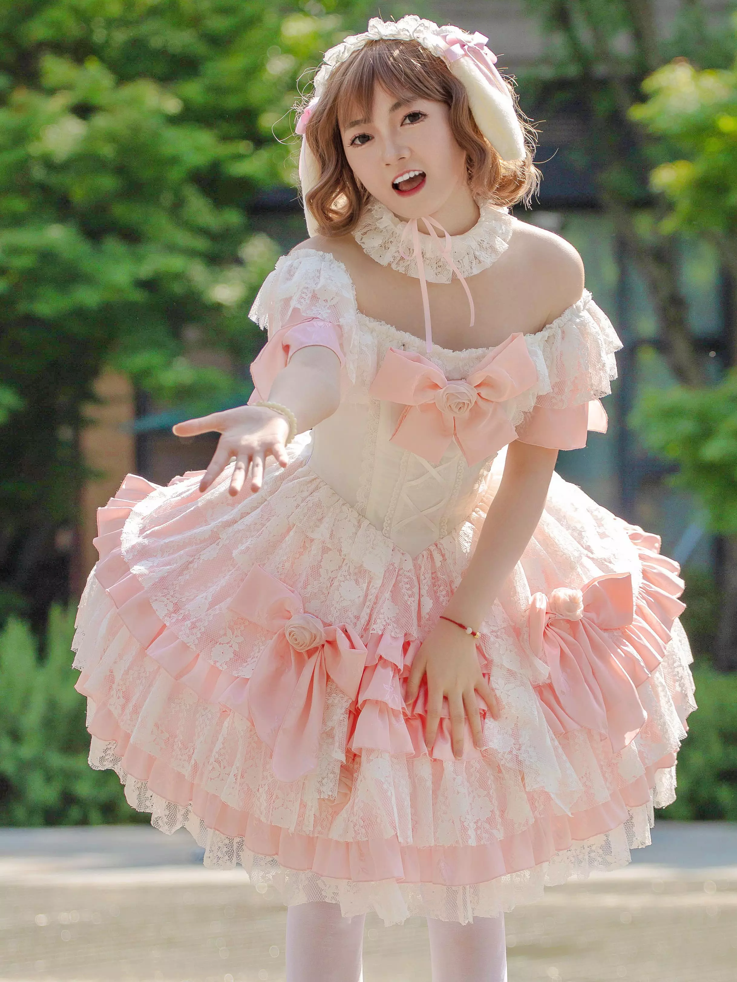 Sweet lolita dress featuring ruffled skirt trim and prominent chest bow with matching neck choker in outdoor park setting