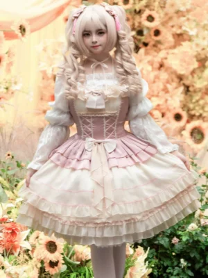 Front full-body view of enchanted garden sweet lolita jsk dress in pink beige featuring ruffled lace hem layered skirt and lace-up corset bodice on blonde model with twin-tails wearing sunflower floral background styling