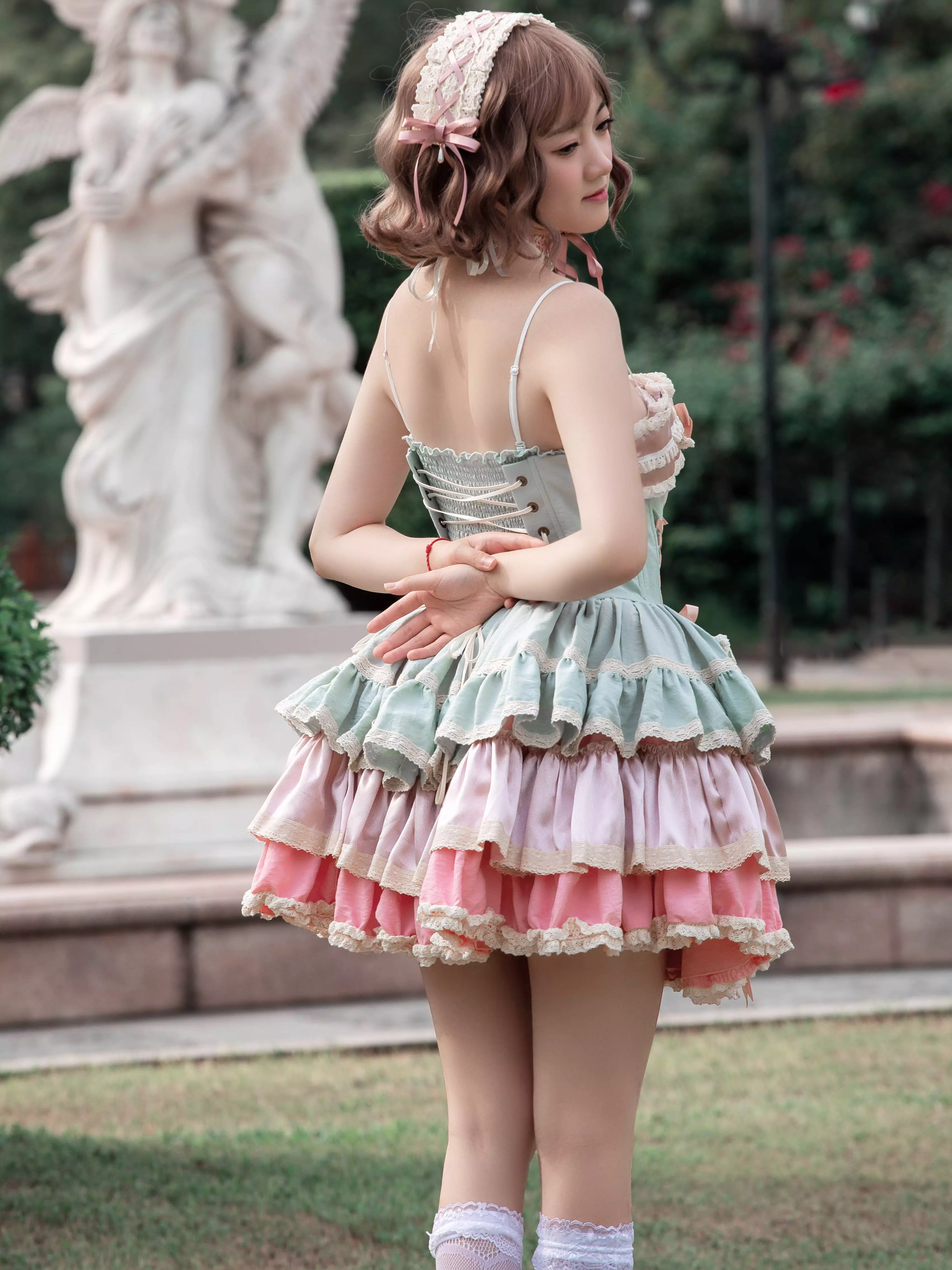 Sweet lolita bunny ear dress back view revealing large decorative satin bow and cascading tiered ruffled skirt construction detail