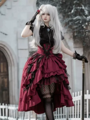 Gothic lolita two-piece dress set with black jacquard lace blouse and wine-red high-low tiered ruffle skirt worn with fishnet stockings, front three-quarter view