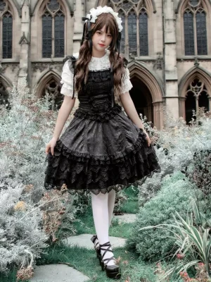 Gothic Lolita JSK dress side-front view showing shirred bodice, layered ruffled skirt, white stockings, and platform loafers on stone garden path