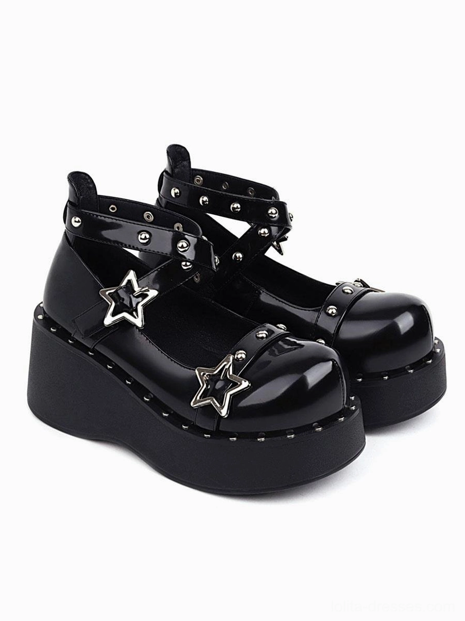Black patent leather wedge heel lolita shoes front three-quarter pair view with silver star buckles and studded ankle straps on white background