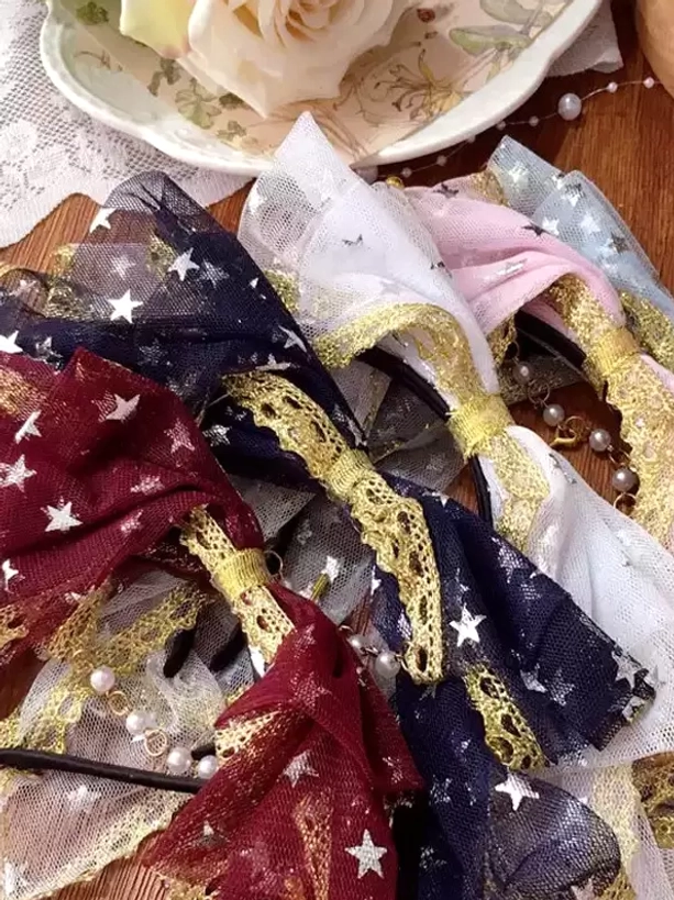 Assorted multicolor lolita bow accessories flat lay showing multiple color options with matching gold lace and pearl chains on floral saucer and lace cloth