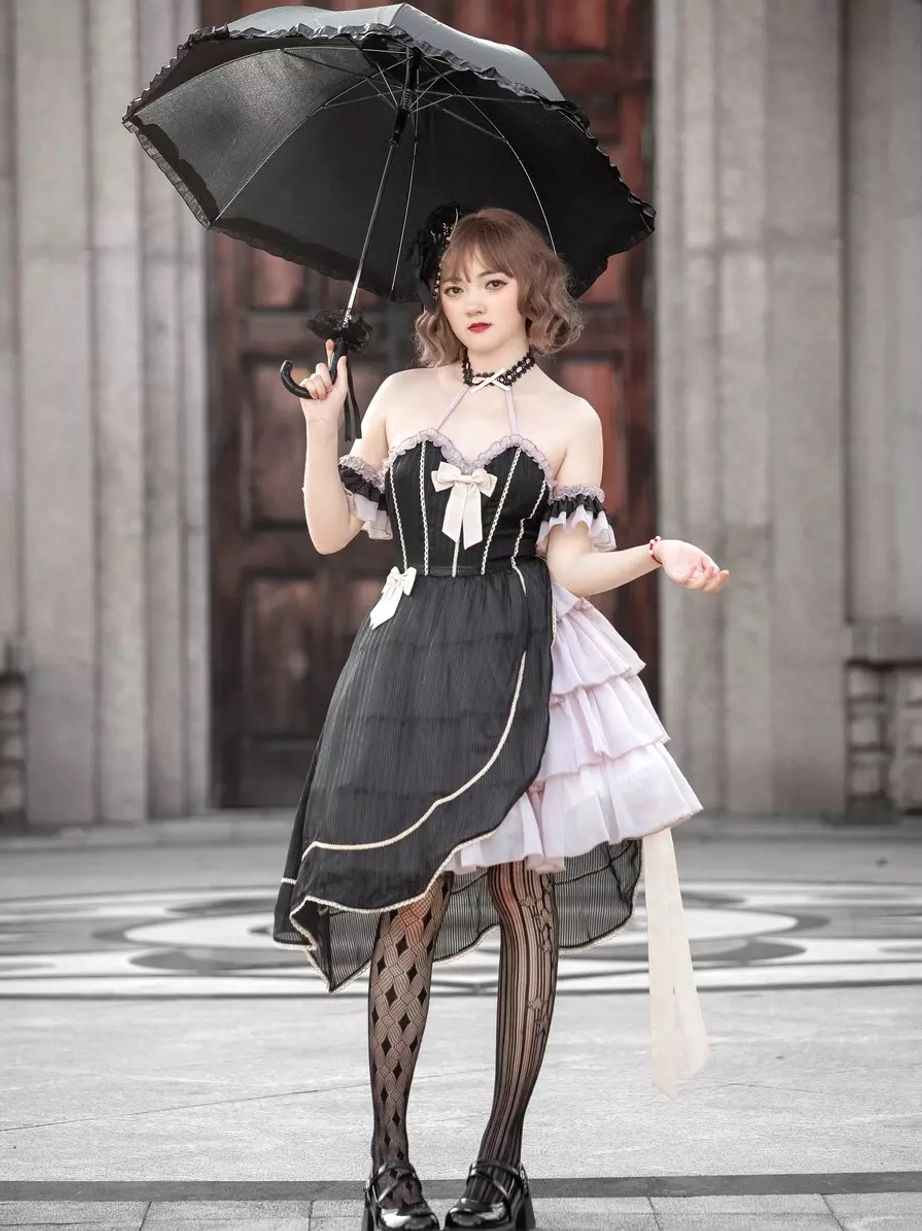 Asymmetrical gothic lolita dress direct front full-body view female model vintage building background holding black umbrella overhead striped patterned stockings