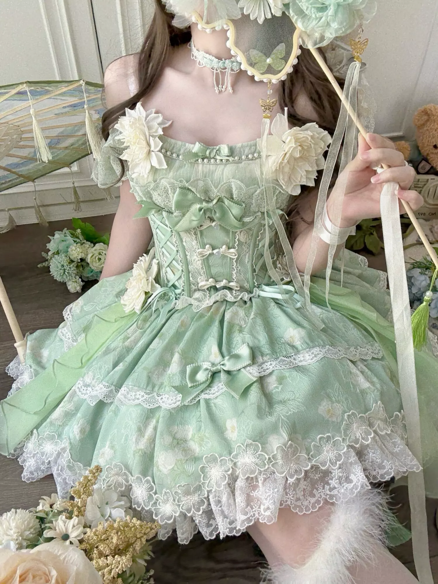Green lolita dress detail of bow placement and floral lace appliques showing sweet aesthetic design elements and embellishments