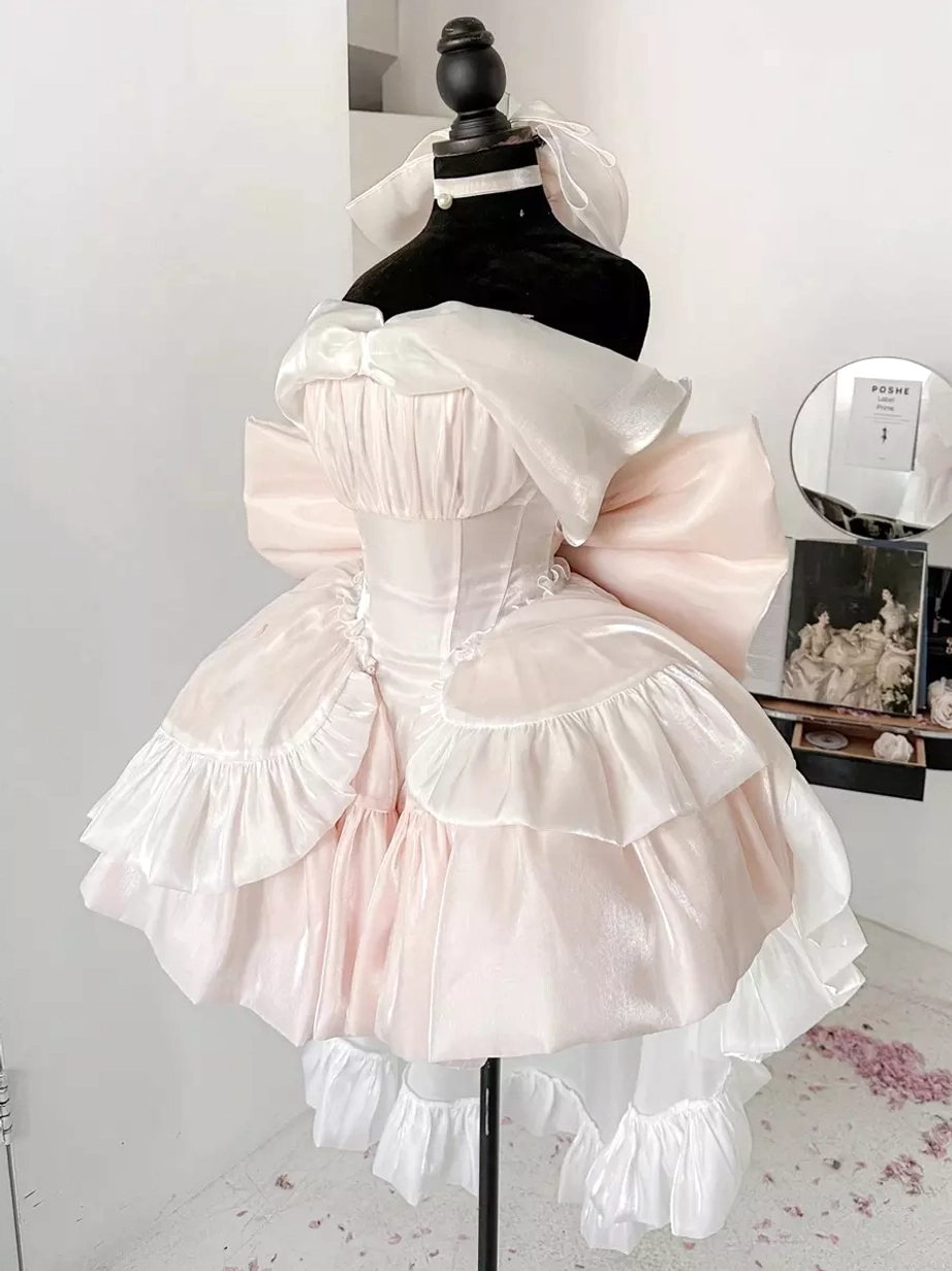 Pale pink corset-style sweet Lolita princess dress with large back bow and ruffled trim on mannequin