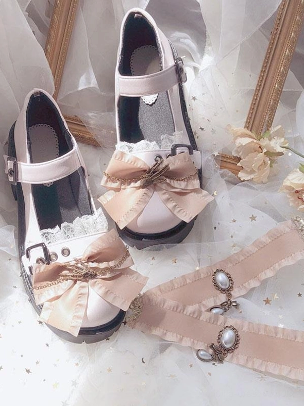 Beige Lolita platform shoes and matching pearl-decorated straps flat lay with satin bow, lace frill, and block heel on star-patterned tulle backdrop with vintage frame