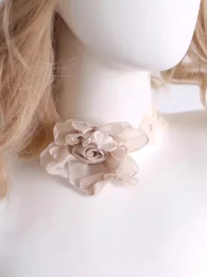 Beige satin rose sweet lolita choker with delicate lace trim and pink tie straps worn on mannequin with blonde hair, close-up left side view showing 3D dimensional rose ornament and intricate lace neckband detail