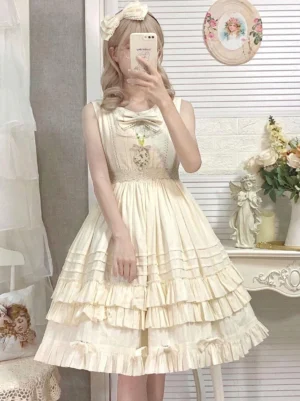 Beige sleeveless sweet lolita jsk dress with embroidered chest bow and tiered ruffled skirt worn by model in vintage indoor setting