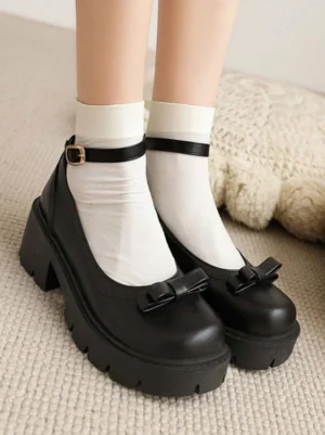 Black academic lolita Mary Jane pumps with decorative bow accent and round toe, featuring chunky platform heel and adjustable ankle strap buckle, modeled with white crew socks on carpeted floor