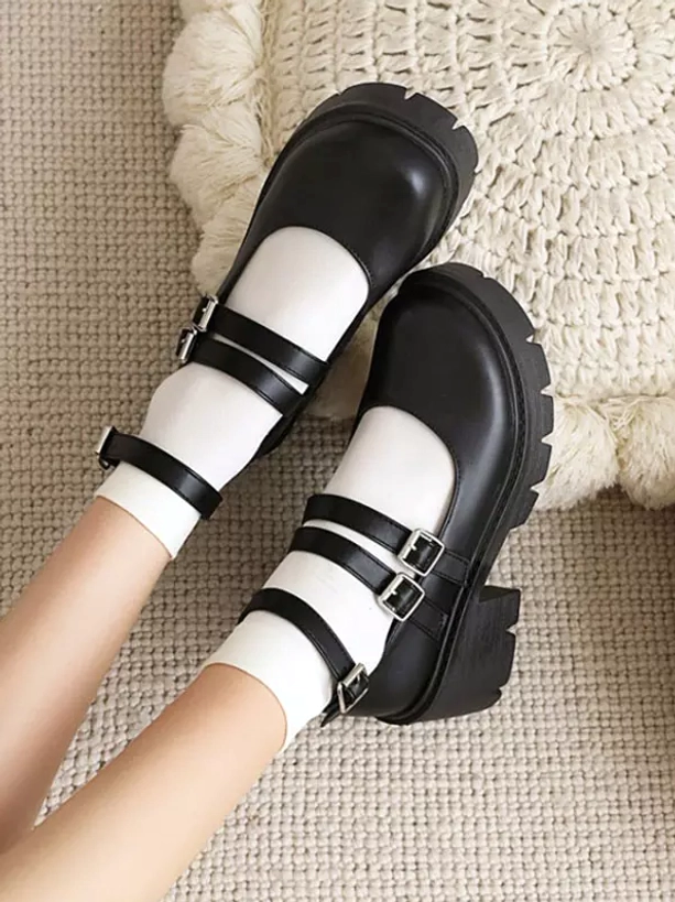 Top down flat lay view of black lolita Mary Jane pumps with white socks showing dual buckle straps and platform sole