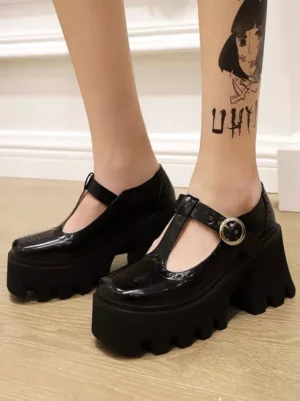 Black PU leather academic lolita T-strap platform pumps close-up front view showing patent leather finish and round metal buckle detail