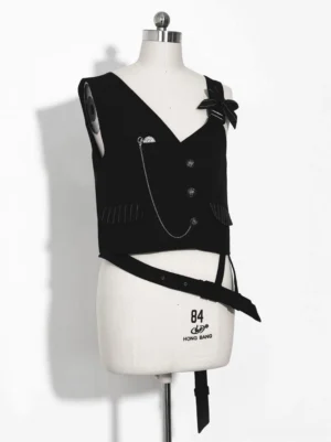 Black asymmetrical ouji waistcoat front flat view with V-neck, metal chain trim, decorative bow, and detachable belt on dress form