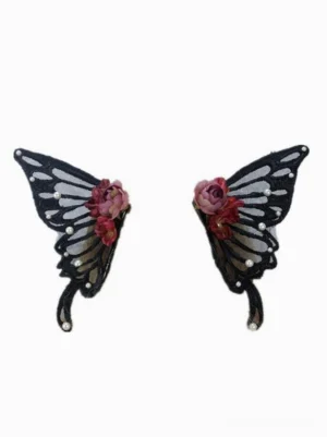 Pair of black butterfly wing lolita hair clips flat lay front view showing sheer dark mesh wings with faux roses and pearl decorations on white background