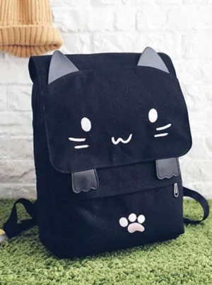 Black cat-themed casual lolita backpack three-quarter front angle showing grey contrast cat ears and cute facial pattern details against white brick wall