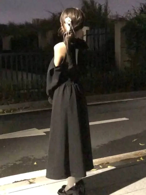 Back view of black classic lolita maxi dress showing swing skirt silhouette, cinched waist construction, and full length maxi hemline on model