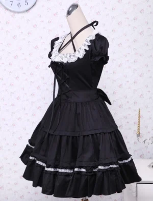 Black classic lolita dress left side view showing cross halter strap, fitted waist bow, and voluminous layered ruffled skirt construction