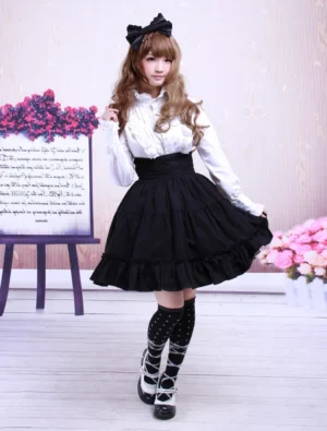 Full front view of black cotton Lolita skirt with high waistline and tiered ruffled hem paired with white blouse lace-up knee socks and platform shoes gothic sweet style