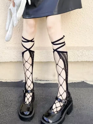Black cross-strap fishnet knee-high socks with hollow diamond mesh pattern worn on lower legs and feet, paired with leather mini skirt and black platform Mary Jane shoes, outdoor street styling for lolita fashion coordination