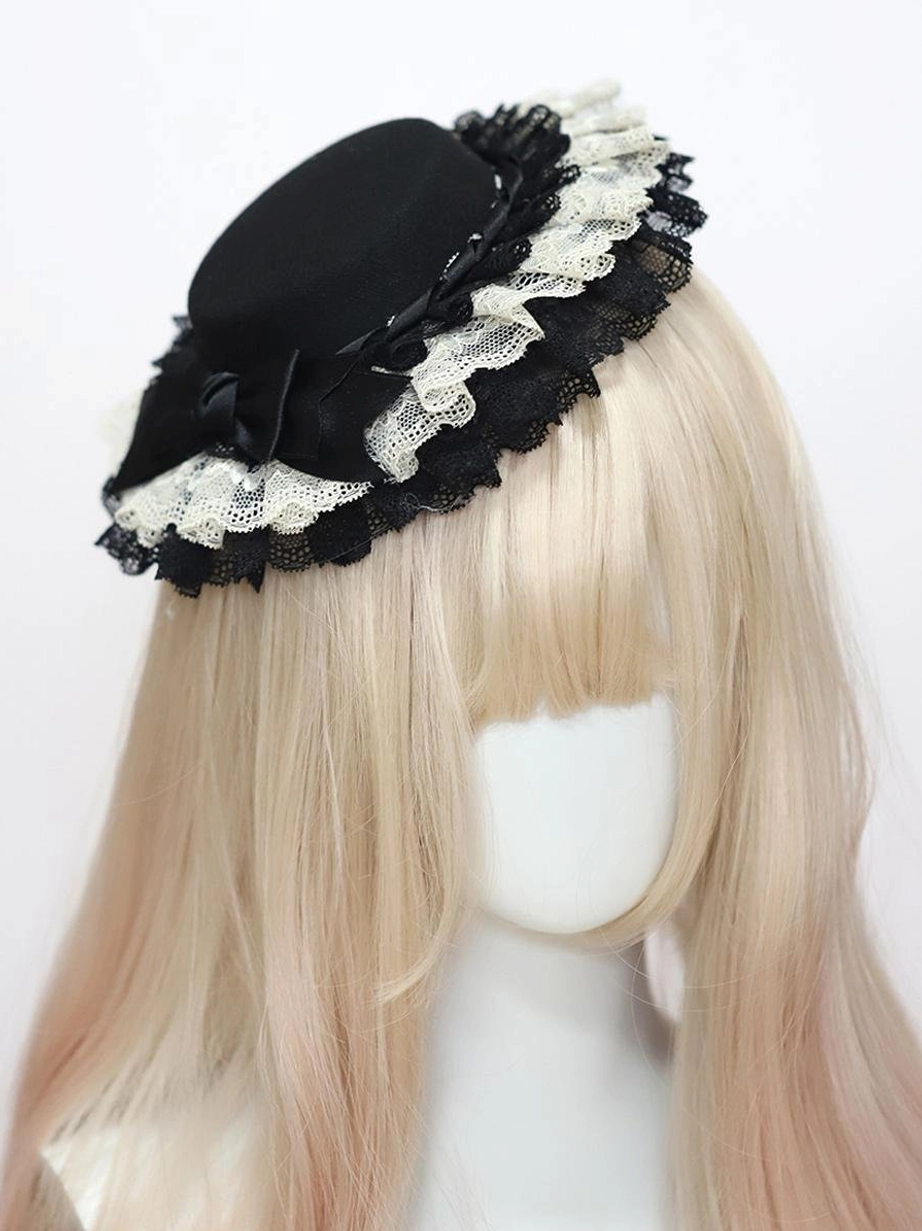 Black crown Classic Lolita headdress with multi-layer ruffled lace and black satin bow embellishment, front three-quarter angle display on mannequin