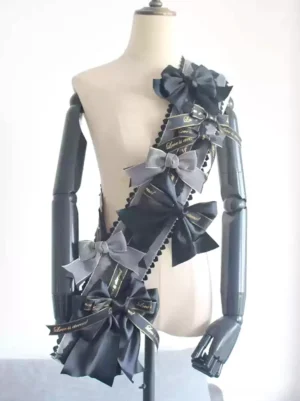 Black and dark grey glossy satin one-shoulder bow accessory with decorative ribbons shown on dress form