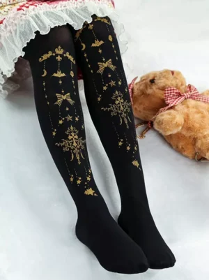 Black demon cross lolita stockings with golden star and bow prints styled with frilled lolita skirt and teddy bear prop low angle leg view