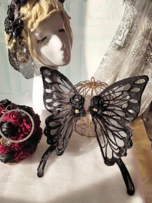 Black lace butterfly hair accessory on vintage mannequin head showing embroidered hollow butterfly wings with red-black headdress styling - lolita headwear side angle