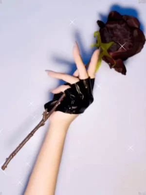 Black fingerless faux leather gloves side profile with dried rose flower prop, shiny leather texture, perfect palm fit with open finger style, gothic romantic aesthetic