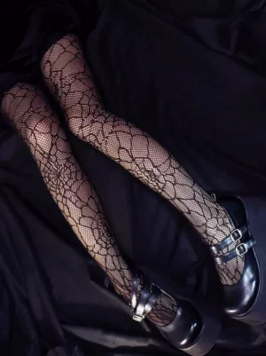 Black floral fishnet lolita stockings with cobweb pattern paired with platform mary jane buckle shoes overhead oblique view gothic hosiery