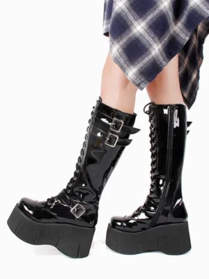 Side view of black gothic knee-high boots with chunky platform sole and multiple metal buckles, styled with blue plaid skirt for lolita fashion coordinate
