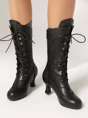 Classic black lolita boots with metal lace eyelets and curved kitten heel paired front studio view