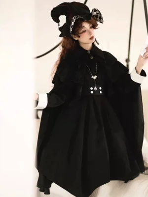 Gothic Lolita black cape poncho side view displaying flowing A-line silhouette and layered capelet details on model wearing checkered witch hat