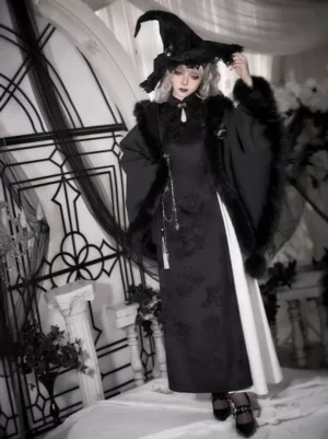 Black Gothic Lolita Cloak Front View with Witch Hat and Furry Trim on Model in Indoor Gothic Setting