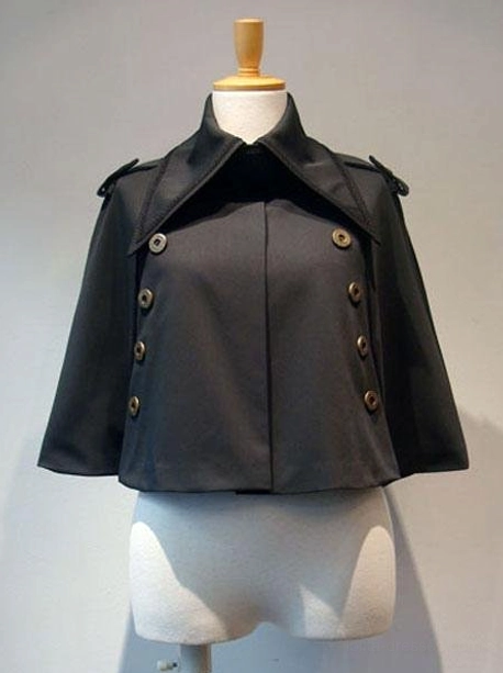Black Gothic Lolita cropped cape front view displayed on dress mannequin featuring double-breasted bronze metallic buttons, wide notched lapel collar, and tailored cropped silhouette perfect for elegant lolita coordinates