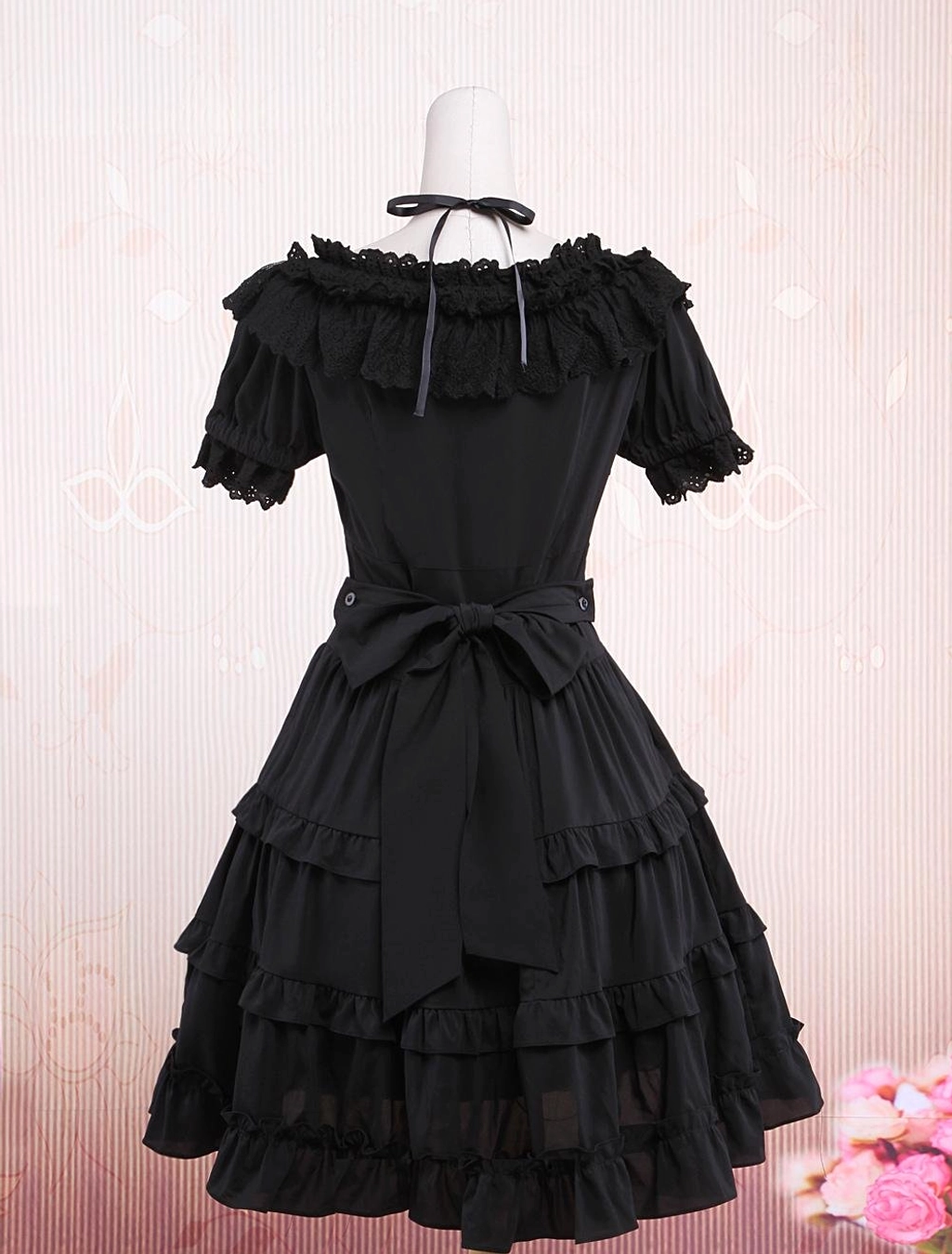 Black lolita dress back view with large detachable bow sash halter strap tie and tiered ruffle midi skirt construction